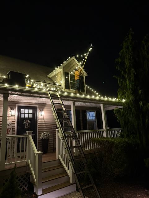 Farmhouse porch and gable outlined in white lights