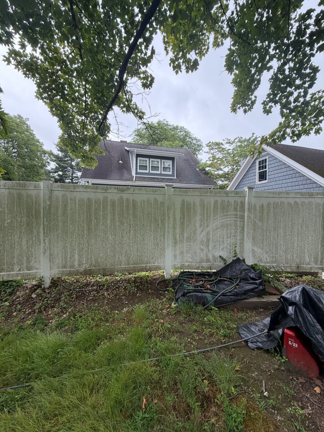 White vinyl fence stained green with mildew